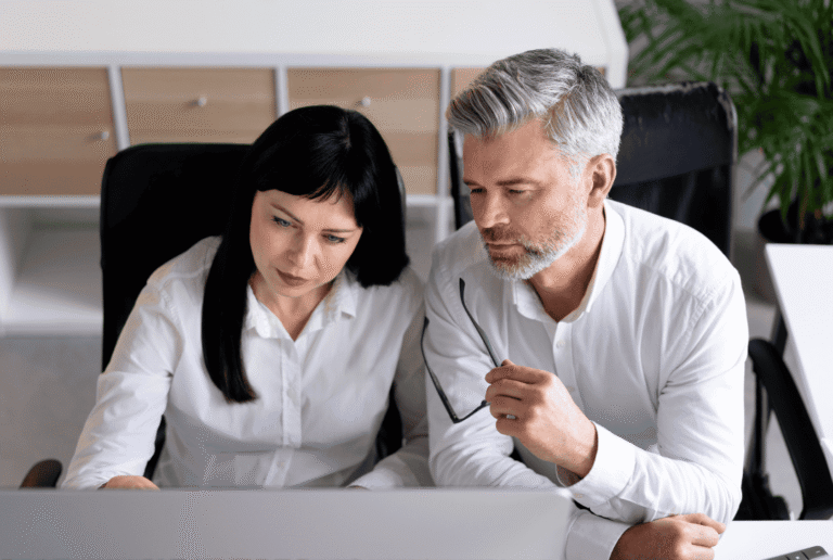 Two people at work reviewing process documentation on a computer screen