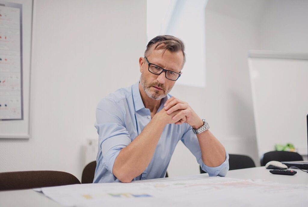 a business owner doing his task and considering how he can prevent being a bottleneck in business