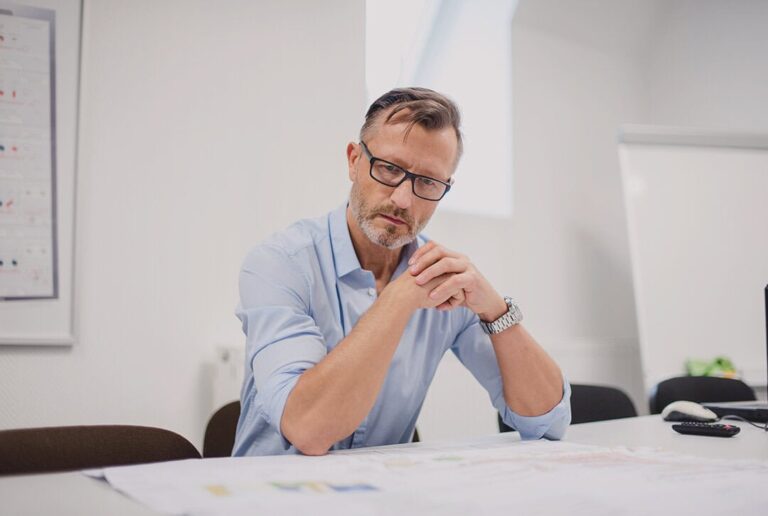 a business owner doing his task and considering how he can prevent being a bottleneck in business