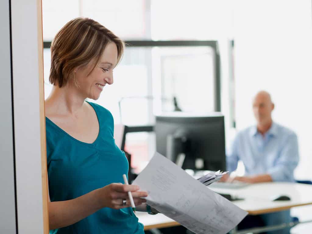 a female business owner looks through post project evaluation results