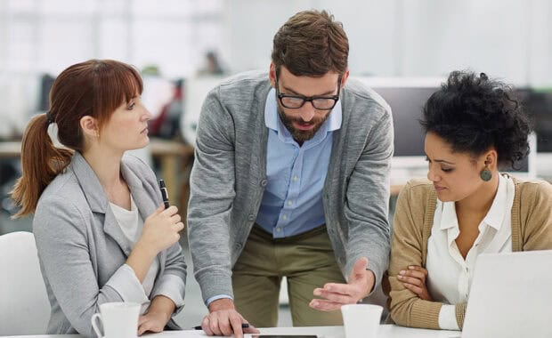 They discuss the cost of poor project management in a team meeting