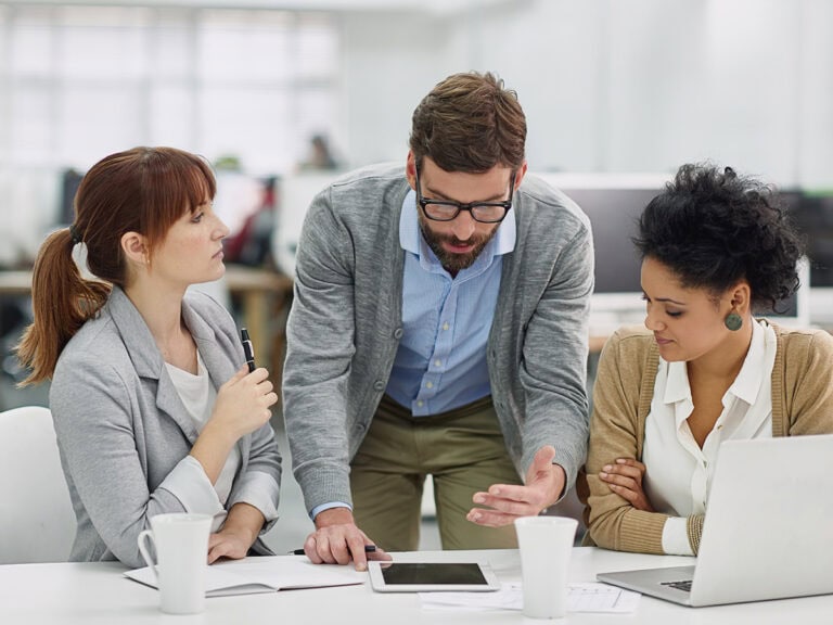 They discuss the cost of poor project management in a team meeting