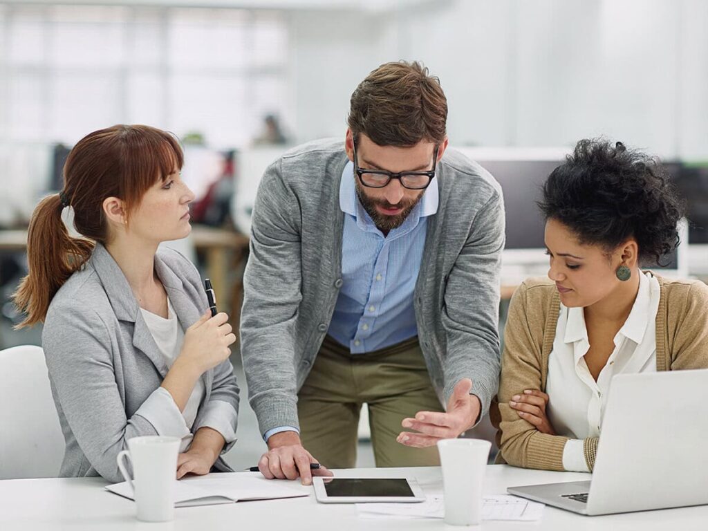 They discuss the cost of poor project management in a team meeting