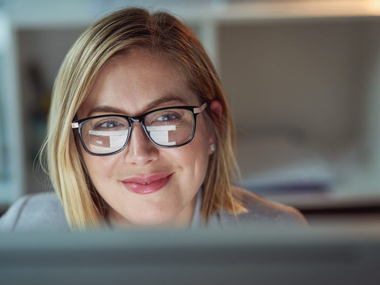 a female small business owner in the process of documenting a business process via her laptop