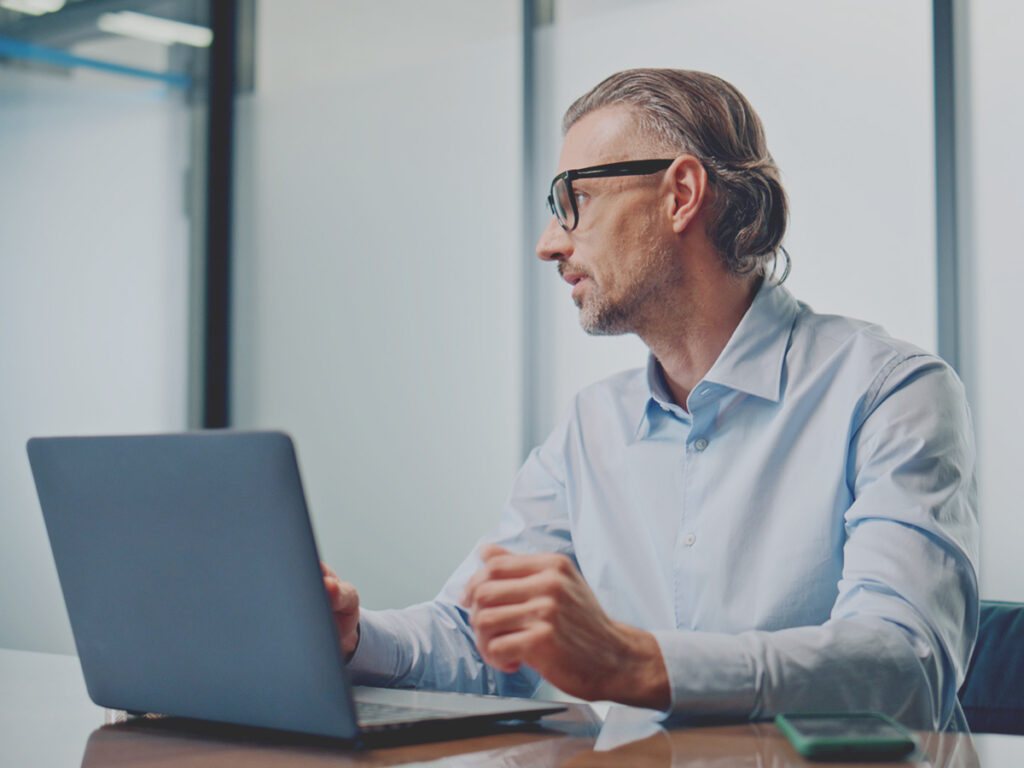 He is documenting business process via his laptop for the small business