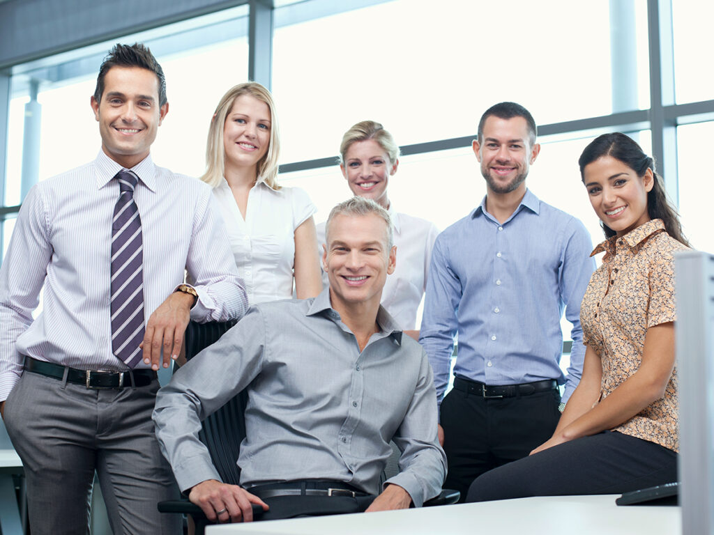 business owner and employees smiling and posing at a camera