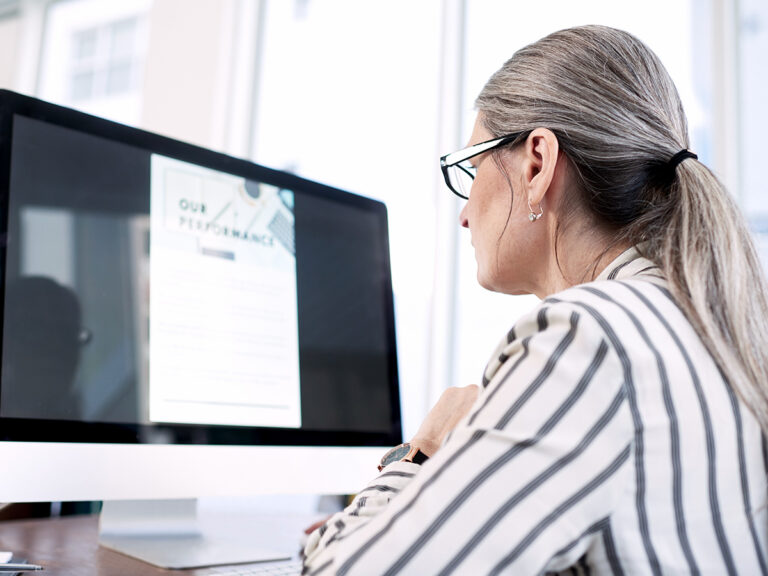 employee viewing monitor with performance document showing employee accountability through a clear tracking system