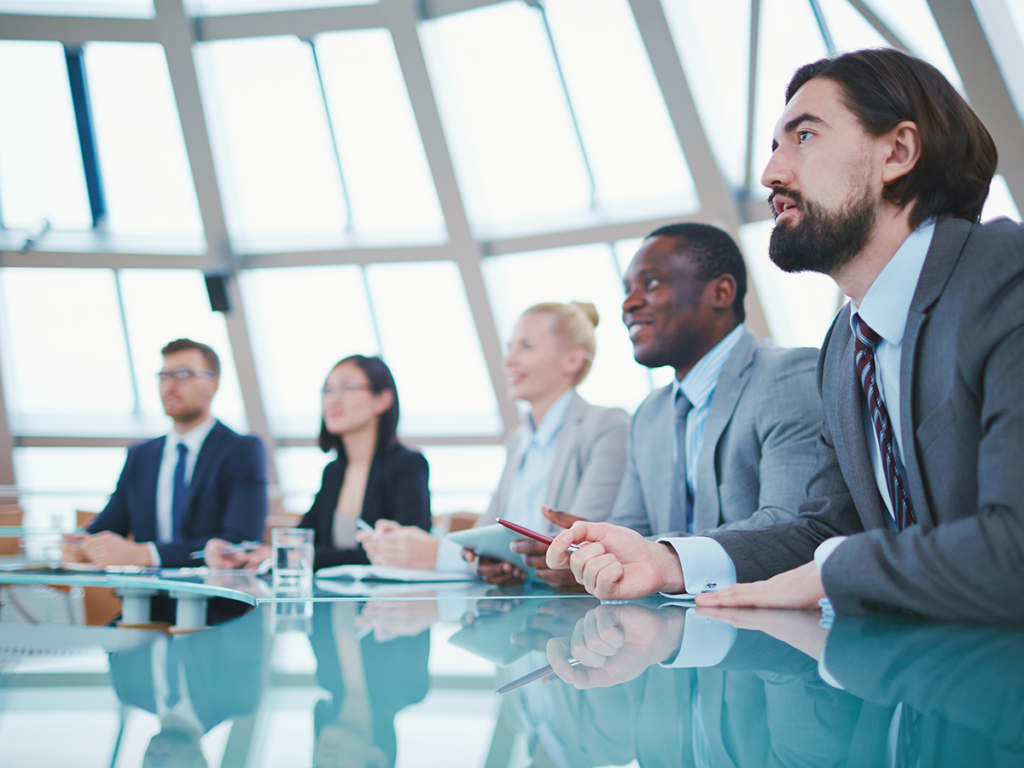 Team attending a meeting on effective delegation in a modern conference room.