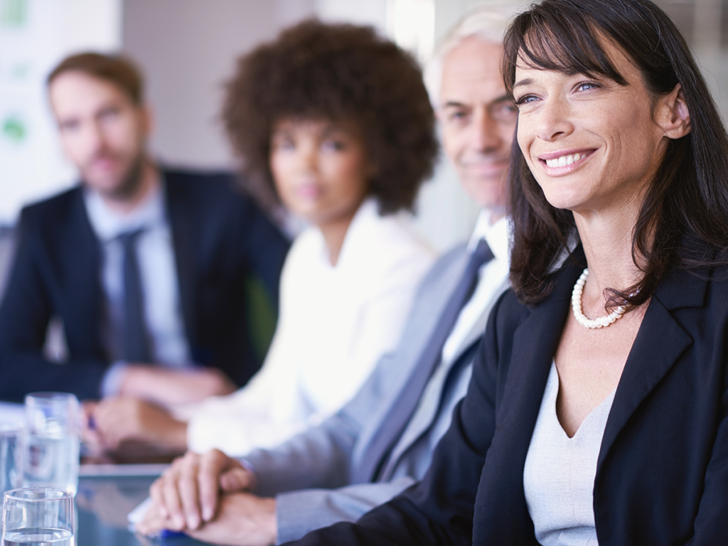 Employees gathered in a conference room discussing a business operations plan.